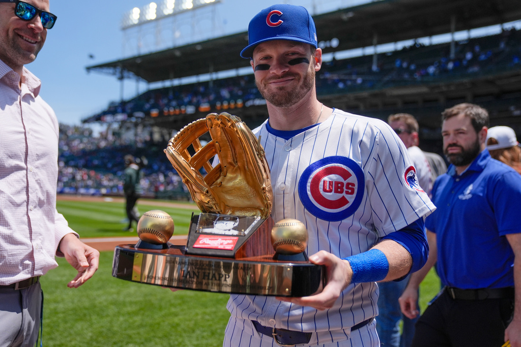 FILE - Chicago Cubs' Ian Happ (8) holds his Gold Glove Award trophy before a baseball game against the Cincinnati Reds, Saturday, May 31, 2025, in Chicago. (AP Photo/Erin Hooley, File)
