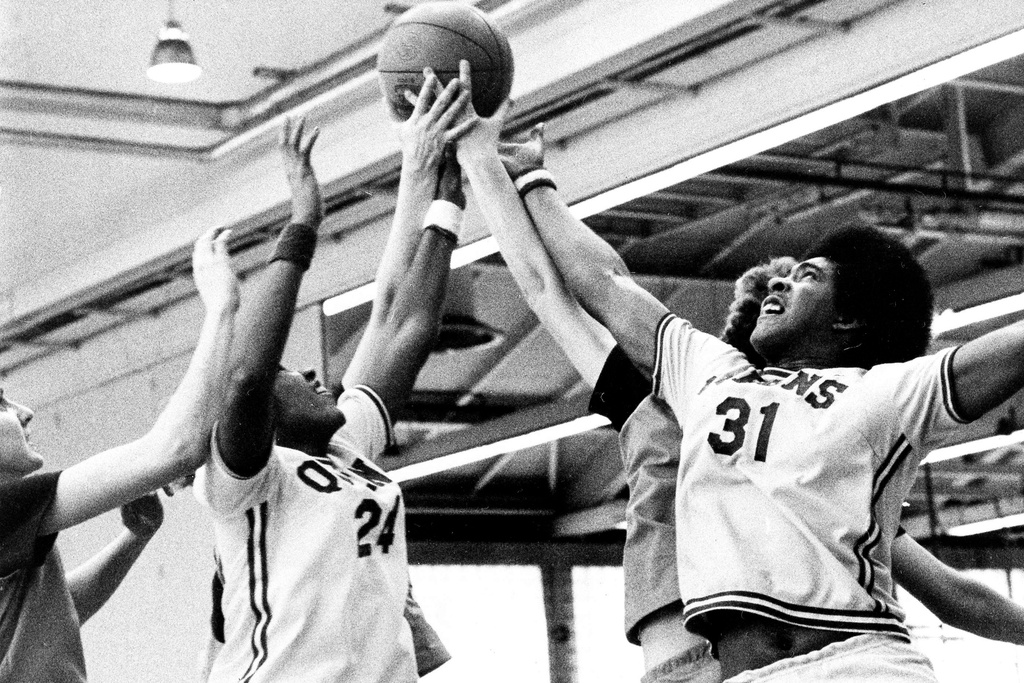 FILE - Queens College's Sharon Manning (24) and teamate Althea Gwyn (31) and Immaculata players vie for a rebound during the second quarter of an AIAW college basketball game at Queens College in the Queens borough of New York, March 6, 1976. (AP Photo/File)