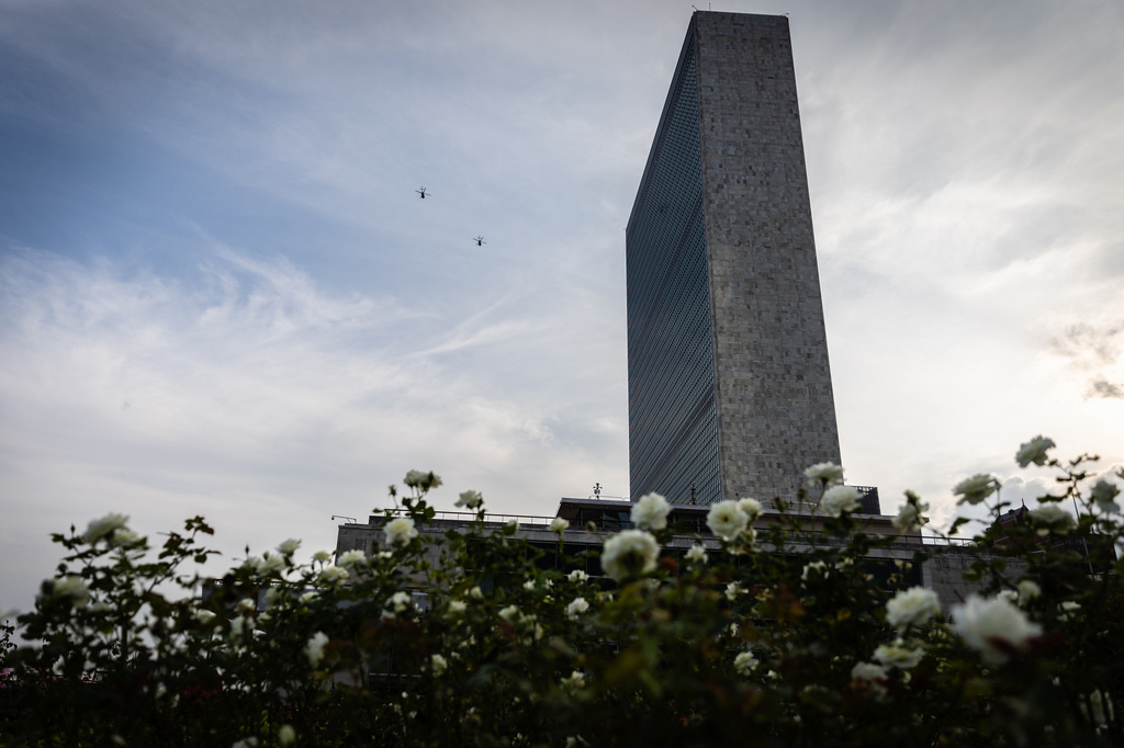 FILE - Military helicopters fly past the United Nations Headquarters building as seen from the rose garden, Sept. 23, 2025. (AP Photo/Stefan Jeremiah, file)