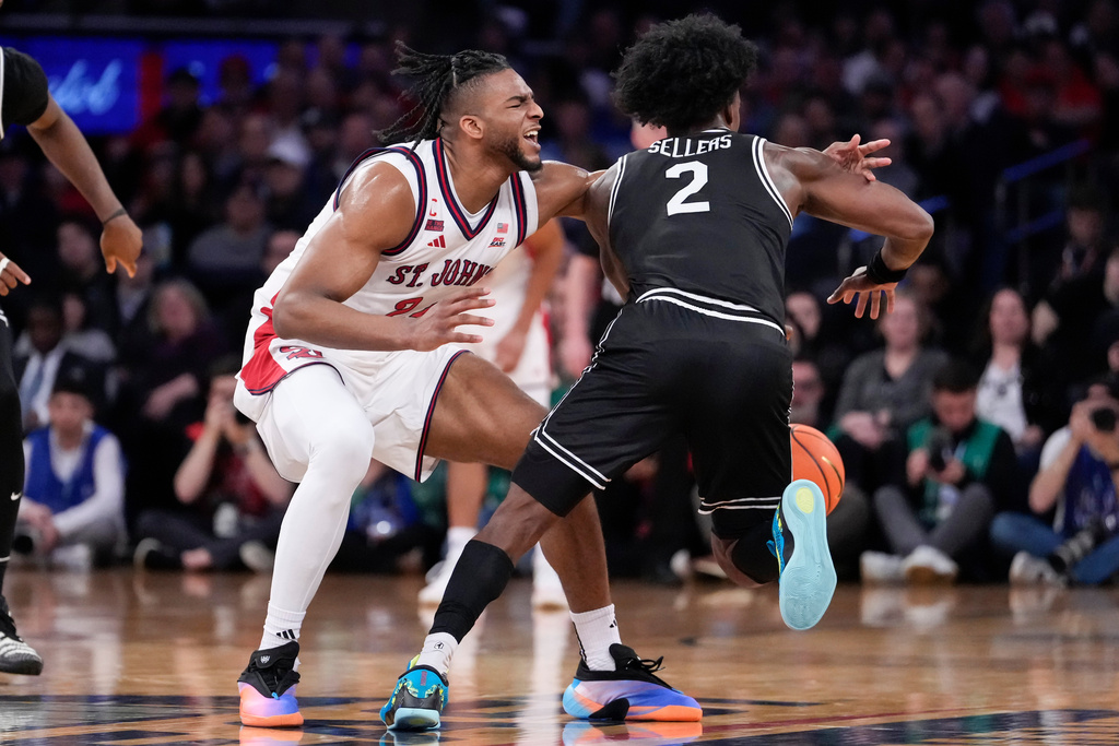 St. John's forward Zuby Ejiofor (24) attempts to block Providence guard Jaylin Sellers (2) during the first half of an NCAA college basketball game in the quarterfinals of the Big East tournament, Thursday, March 12, 2026, in New York. (AP Photo/Yuki Iwamura)