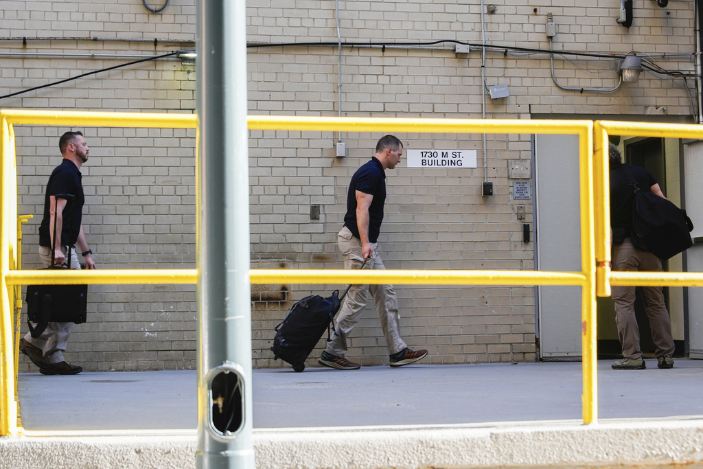FBI agents walk inside the back entrance of ex-Trump national security adviser John Bolton's Washington office, Friday, Aug 22, 2025. (AP Photo/Julia Demaree Nikhinson)