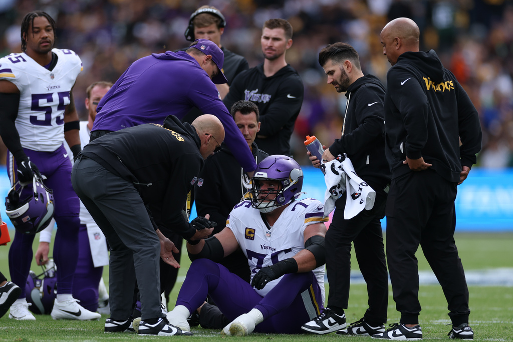 Minnesota Vikings offensive tackle Brian O'Neill (75) is helped to get up during the NFL football game between Minnesota Vikings and Pittsburgh Steelers at Croke Park stadium in Dublin, Sunday, Sept. 28, 2025.(AP Photo/Ian Walton)