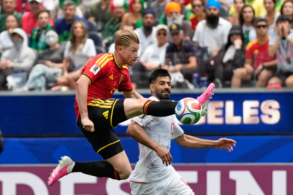 Belgium's Kevin De Bruyne, front, tries control the ball past Iran's Hossein Kanani during the World Cup Group G soccer match between Belgium and Iran in Inglewood, Calif., near Los Angeles, Sunday, June 21, 2026. (AP Photo/Andre Penner)