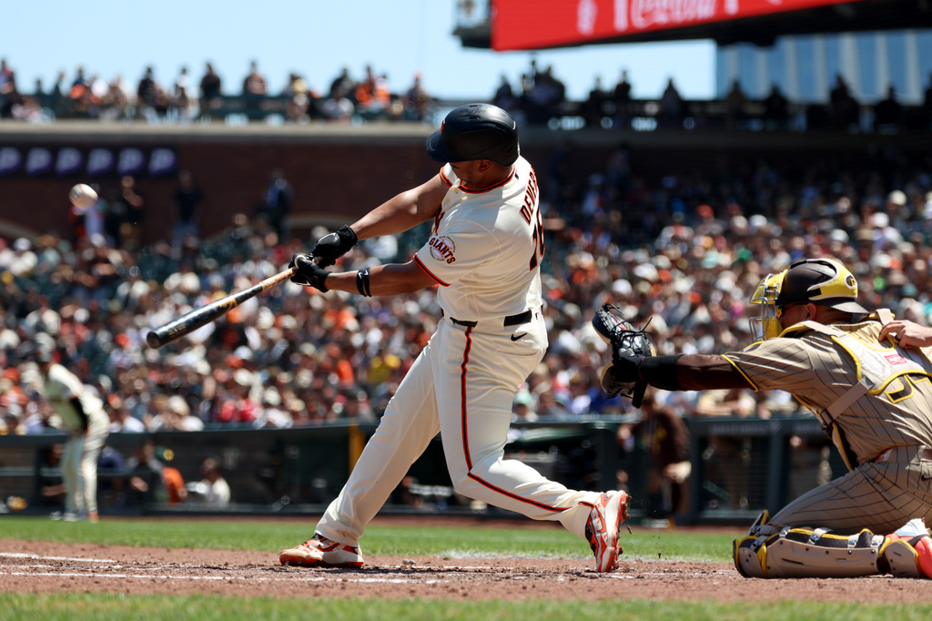 San Francisco Giants' Rafael Devers, left, hits a home run in front of San Diego Padres catcher Freddy Fermin during the fifth inning of a baseball game in San Francisco, Wednesday, May 6, 2026. (AP Photo/Jed Jacobsohn)