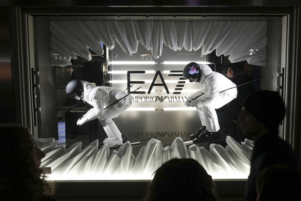 FILE - People watch the shop window during an event celebrating the Milan Cortina 2026 Winter Olympics at the Emporio Armani store during the Fall/Winter 2026-2027 men's fashion week in Milan, Italy, Jan. 17, 2026. (AP Photo/Antonio Calanni, File)