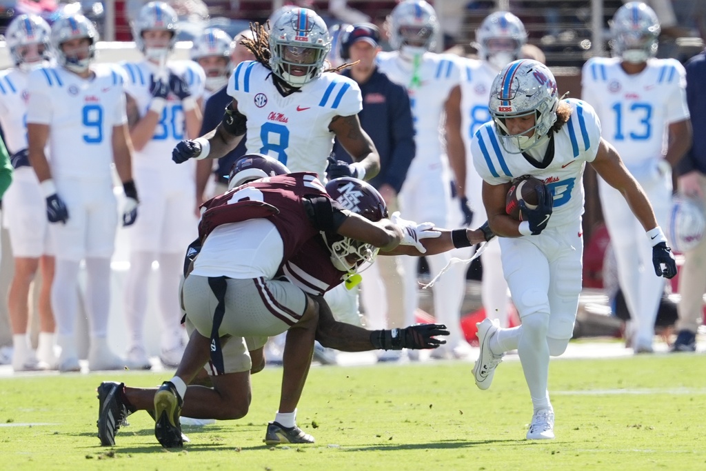 Mississippi State defenders get entangled a Mississippi wide receiver Cayden Lee (19) runs past with a first down pass reception during the first half of an NCAA college football game Frifday, Nov. 28, 2025, in Starkville, Miss. (AP Photo/Rogelio V. Solis)