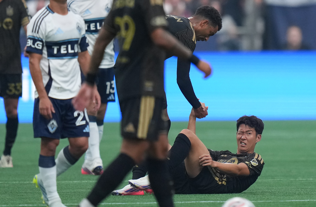 Los Angeles FC's Son Heung-min, right, is helped up by teammate Timothy Tillman after a collision with Vancouver Whitecaps' Mathias Laborda, not seen, during the first half of an MLS soccer match, in Vancouver, on Saturday, August 1, 2026. (Darryl Dyck/The Canadian Press via AP)