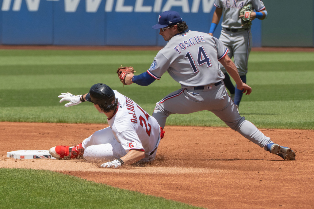Cleveland Guardians' Chase DeLauter (24) slides safely into second base as Texas Rangers' Justin Fosque (24) is late with the tag during the first inning of a baseball game, Wednesday, July 1, 2026, in Cleveland. (AP Photo/Phil Long)