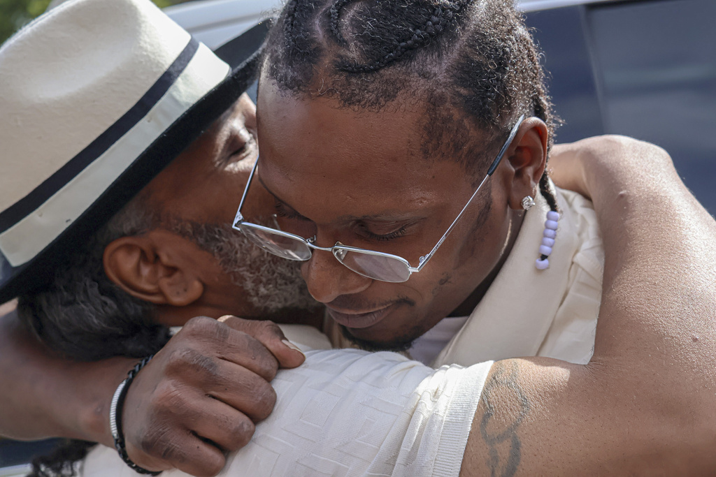 After a judge found him innocent of a 1998 murder, Bryan Hooper Sr., left, embraces his son Bryan Hooper Jr. outside Stillwater Prison on Thursday, Sept. 4, 2025 in Bayport, Minn. (Matt Sepic/Minnesota Public Radio via AP)