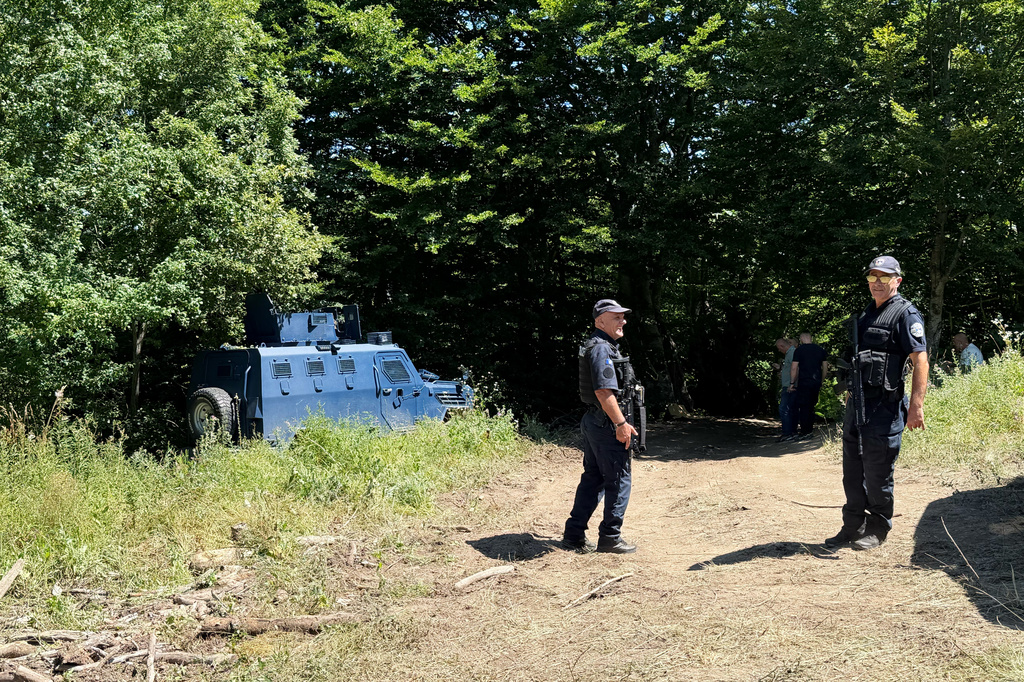 Kosovo policemen guard the site where forensic teams have begun excavations of a mass grave near the village of Kalluder, Wednesday, July 29, 2026. (AP Photo/Florent Bajrami)