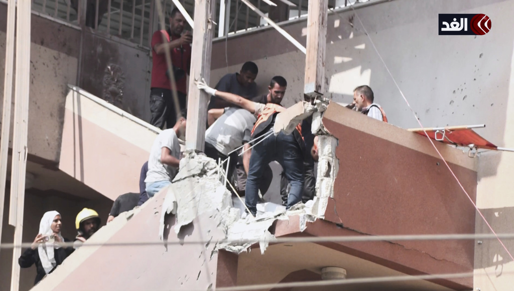 This frame grab taken from a video released by Al Ghad TV shows AP freelancer Mariam Dagga, bottom left, and other journalists, rescue workers, hospital staff, and others as they arrive to document the scene and help the wounded at Nasser Hospital shortly after the first of two rounds of Israeli strikes hit in Khan Younis, southern Gaza Strip, Monday, Aug. 25, 2025. (Al Ghad TV via AP)