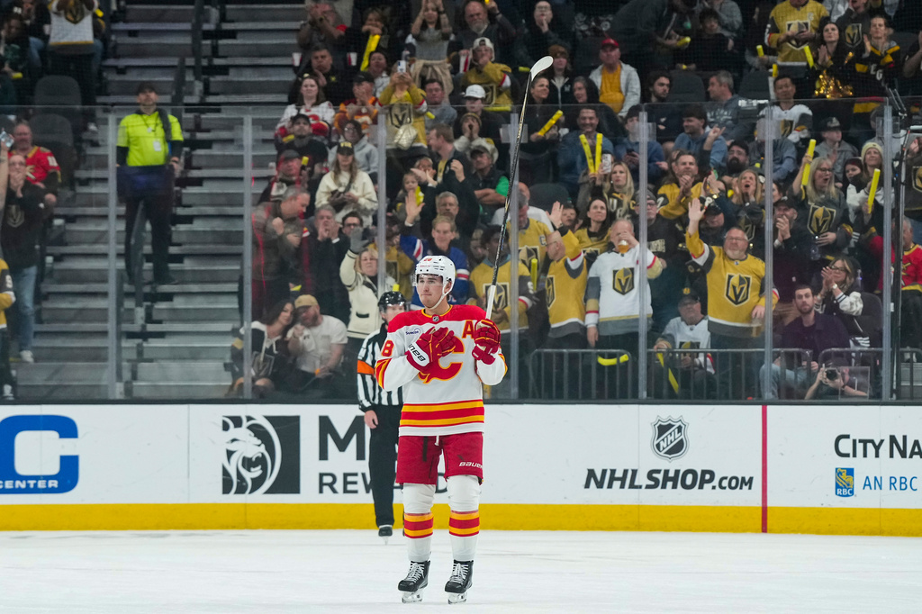 Calgary Flames defenseman Zach Whitecloud, center, salutes the fans during the first period of an NHL hockey game against the Vegas Golden Knights, Thursday, April 2, 2026, in Las Vegas. (AP Photo/Candice Ward)