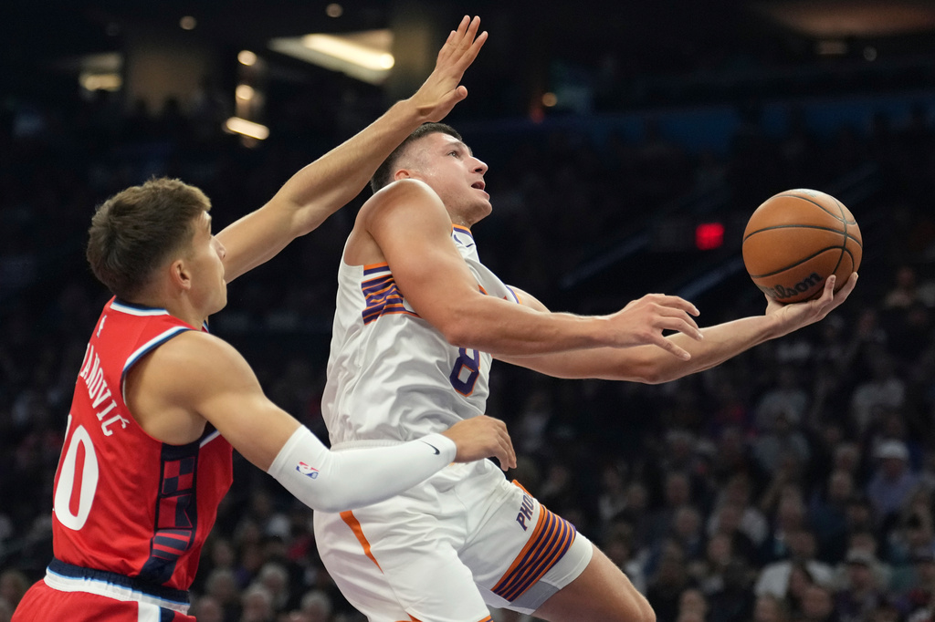 Phoenix Suns guard Grayson Allen (8) drives past Los Angeles Clippers guard Bogdan Bogdanovic, left, to score during the first half of an NBA basketball game Thursday, Nov. 6, 2025, in Phoenix. (AP Photo/Ross D. Franklin)