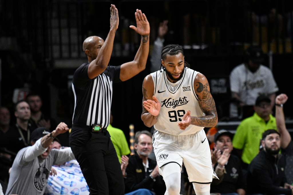 Central Florida forward Jordan Burks (99) reacts after scoring a 3-point basket during the first half of an NCAA college basketball game against Arizona, Saturday, Jan. 17, 2026, in Orlando, Fla. (AP Photo/Phelan M. Ebenhack)