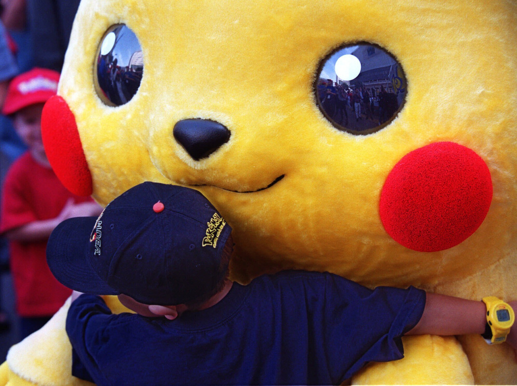 FILE - Daniel Osugi, 7, of Long Beach, Calif., hugs an oversized Pokemon character known as "Pikachu" at the premiere of the new Warner Bros. animated feature, "Pokemon The First Movie," Nov. 6, 1999, at the Mann's Chinese Theatre, in Los Angeles. (AP Photo/Chris Pizzello, File)