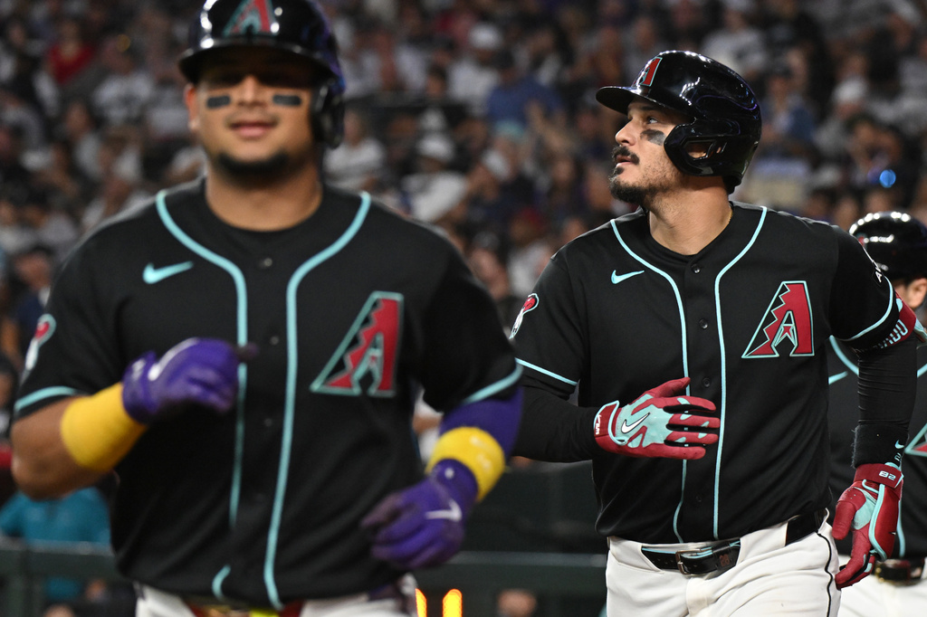 Arizona Diamondbacks' Gabriel Moreno, left, and Nolan Arenado, right, run back toward the dugout after scoring on Arenado's grand slam in the fifth inning of a baseball game against the New York Yankees, Sunday, Sept. 20, 2026, in Phoenix. (AP Photo/Caitlin O'Hara)