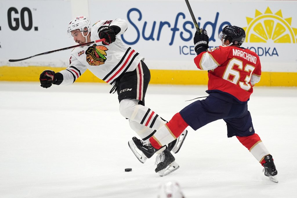 Florida Panthers left wing Brad Marchand (63) and Chicago Blackhawks defenseman Artyom Levshunov clash during the first period of an NHL hockey game, Tuesday, Oct. 7, 2025, in Sunrise, Fla. (AP Photo/Rebecca Blackwell)
