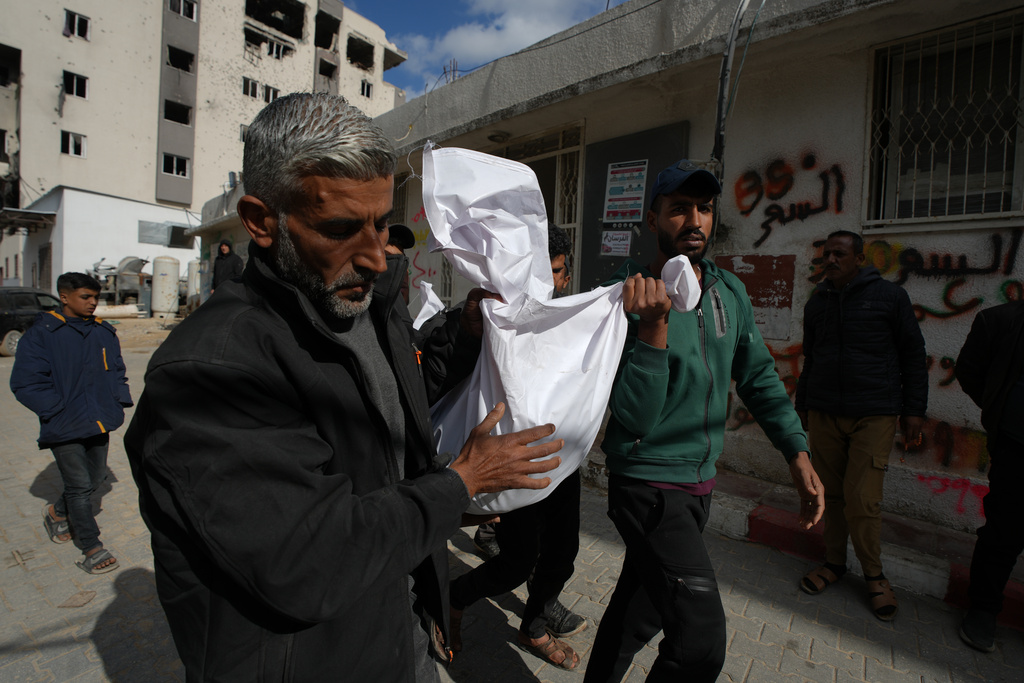 Mourners carry the bodies of two members of Hamas, Muhammad Abu Jabal, and Ali al-Burdini who were killed in an Israeli military strike, at Shifa Hospital in Gaza City Thursday, Feb. 26, 2026. (AP Photo/Jehad Alshrafi)