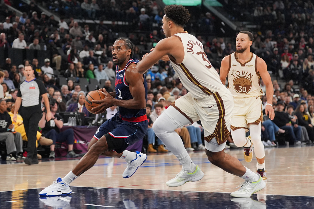 Los Angeles Clippers forward Kawhi Leonard (2) drives past Golden State Warriors forward Trayce Jackson-Davis (32) as Warriors guard Stephen Curry (30) watches during the first half of an NBA basketball game Monday, Jan. 5, 2026, in Inglewood, Calif. (AP Photo/Jae C. Hong)