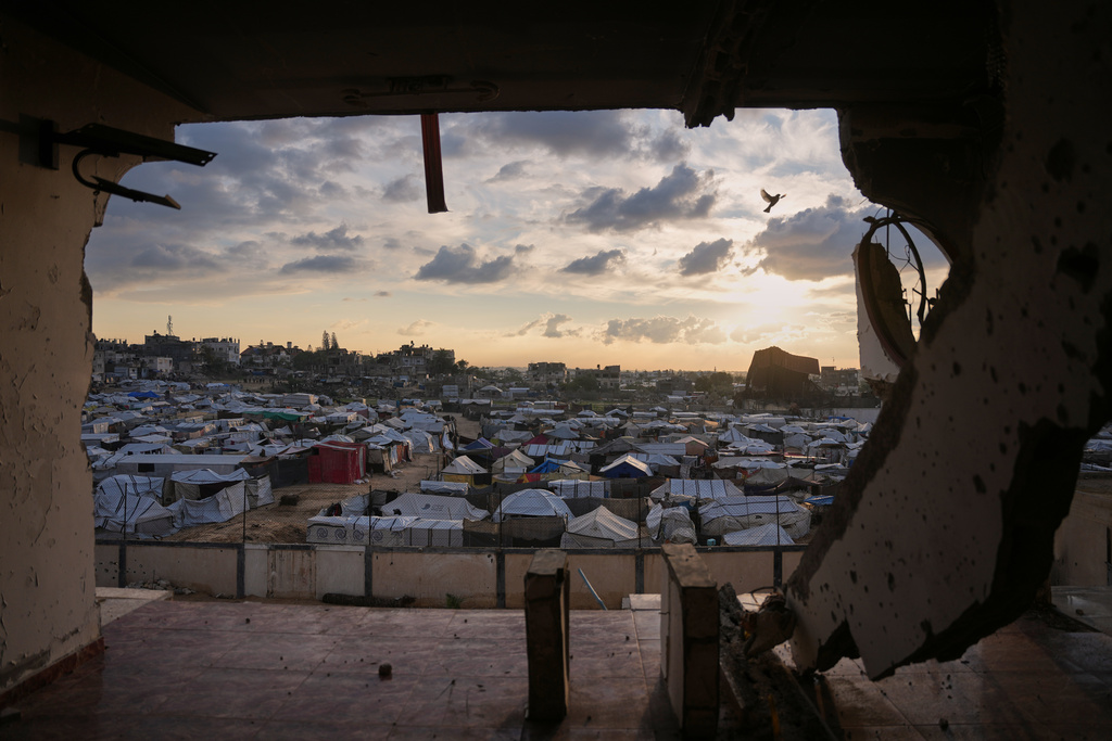 Seen from a building heavily damaged during the Israeli air and ground operations, tents fill a makeshift camp for displaced Palestinians in Deir al-Balah, central Gaza Strip, Saturday, Dec. 13, 2025. (AP Photo/Abdel Kareem Hana)