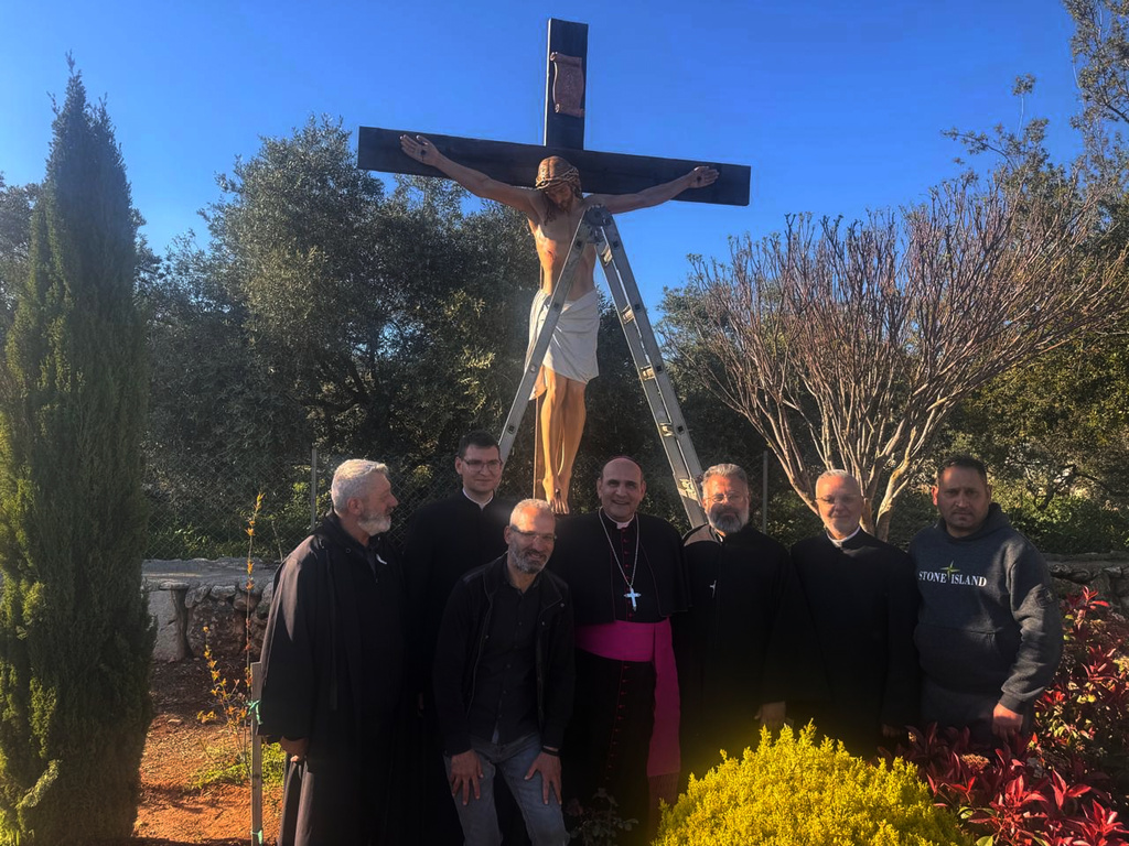 The Apostolic Nuncio to Lebanon Monsignor Paolo Borgia, center, poses with residents next to a crucifix sent by Italy to replace one that was defaced last week by an Israeli soldier in the Christian village of Debel, south Lebanon, Wednesday, April 22, 2026. (Houssam Naddaf via AP)
