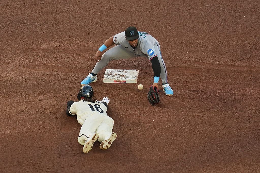Minnesota Twins' Austin Martin (16) dives to beat the throw to Miami Marlins shortstop Otto Lopez (6) during the first inning of a baseball game Wednesday, May 13, 2026, in Minneapolis. (AP Photo/Abbie Parr)