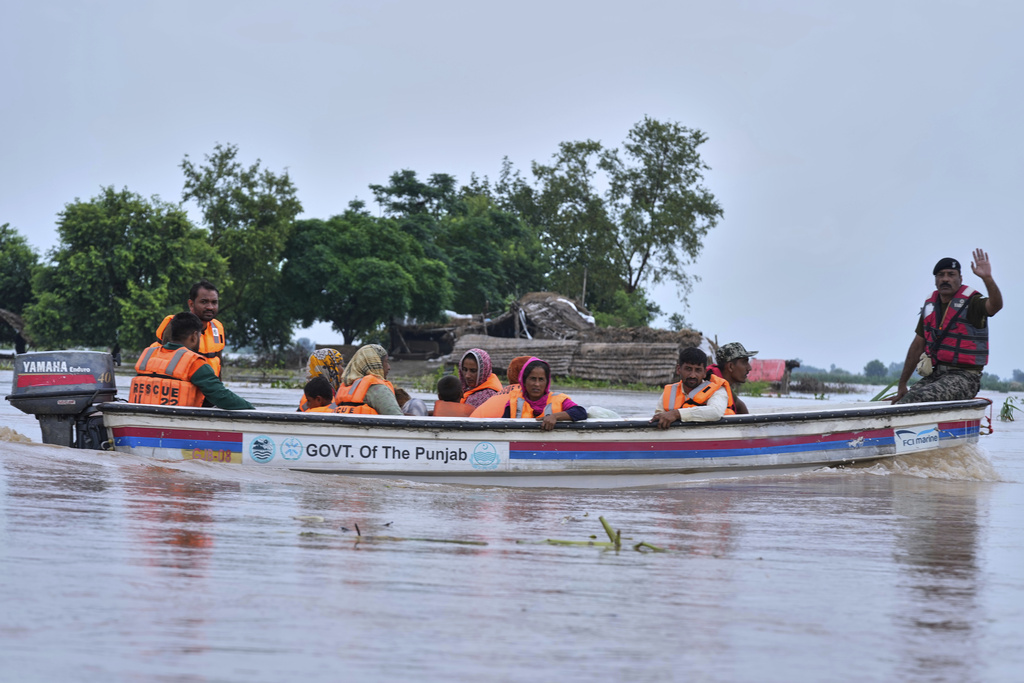 Villagers are evacuated by rescue workers from a flooded area in Dhoop Sarhi village in Kasur district, Pakistan, Tuesday, Aug. 26, 2025, due to the rising water level in Sutlej River, following neighboring India releasing water from overflowing dams. (AP Photo/K.M. Chaudary)