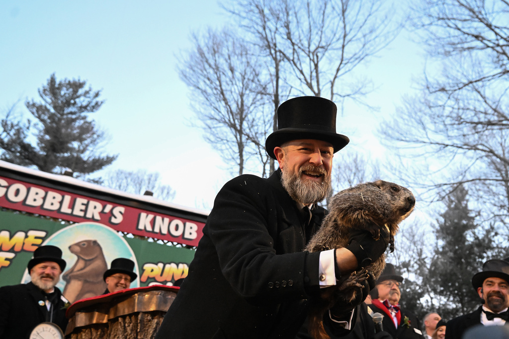 Groundhog Club handler A.J. Dereume holds Punxsutawney Phil, the weather prognosticating groundhog, during the 140th celebration of Groundhog Day on Gobbler's Knob in Punxsutawney, Pa., Monday, Feb. 2, 2026, Phil's handlers said that the groundhog has forecast six more weeks of winter. (AP Photo/Barry Reeger)