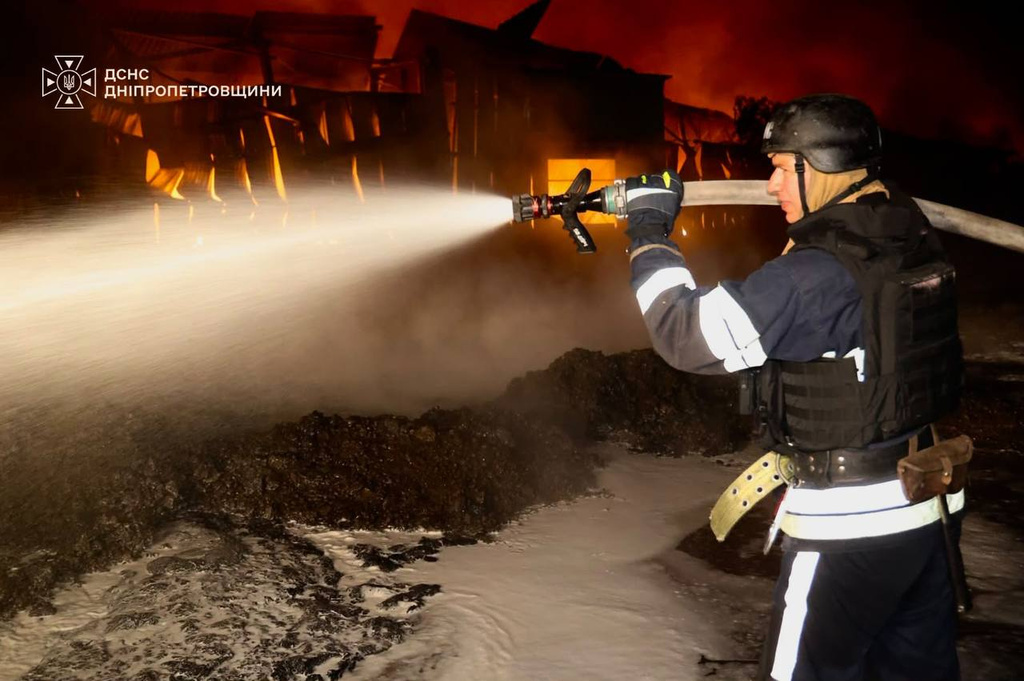 In this photo provided by the Ukrainian Emergency Services on Tuesday, Sept. 22, 2026, a rescue worker put out a fire of a infrastructure facility damaged after a Russian strike on Dnipropetrovsk region, Ukraine. (Ukrainian Emergency Service via AP)