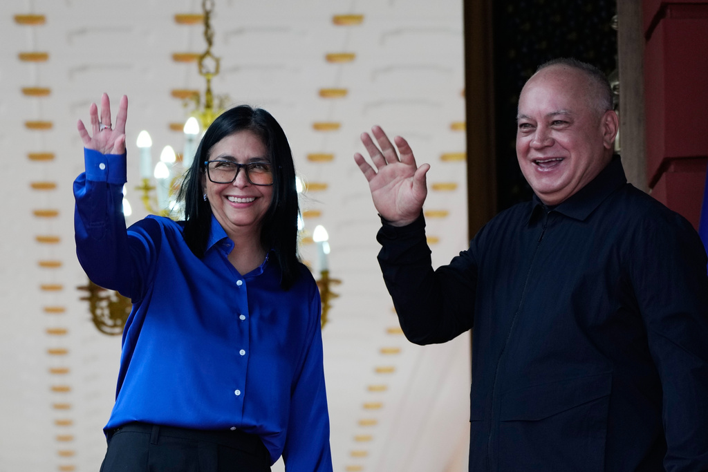 Venezuela's acting President Delcy Rodriguez and Interior Minister Diosdado Cabello, right, wave before making a statement at Miraflores presidential palace in Caracas, Venezuela, Wednesday, Jan. 14, 2026. (AP Photo/Ariana Cubillos)