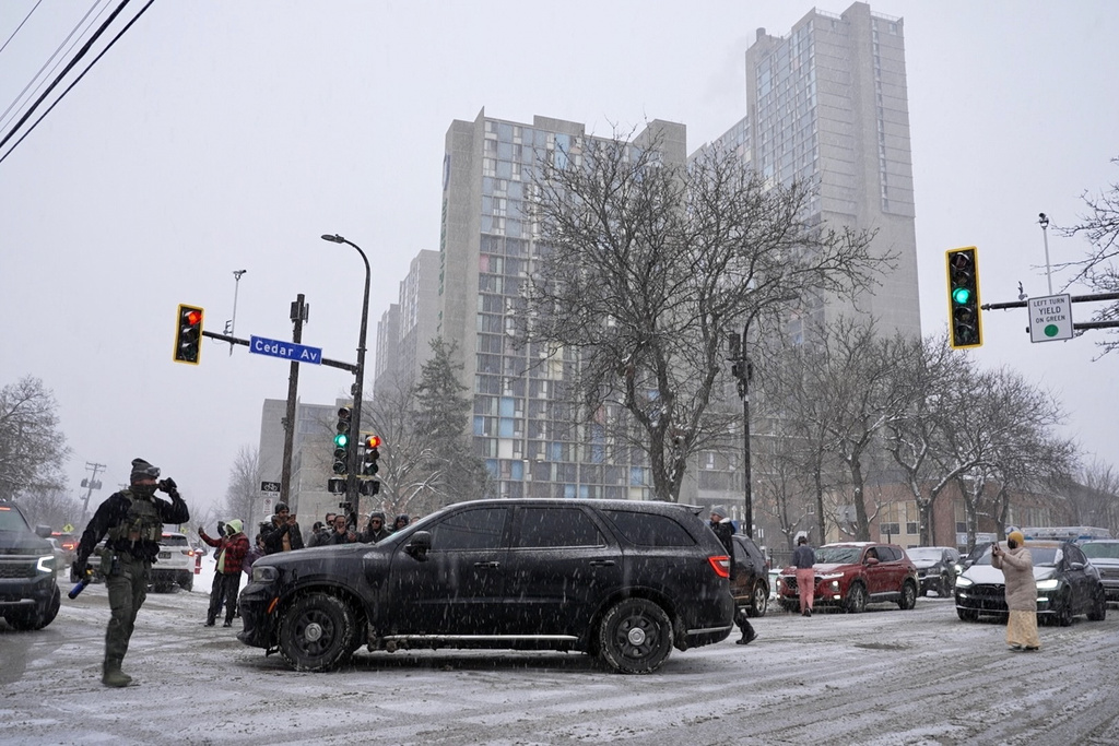 Activists confronted a group of Immigration and Customs Enforcement officers in the largely Somali neighborhood of Cedar-Riverside in Minneapolis, Tuesday, Dec. 9, 2025. (AP Photo/Mark Vancleave)