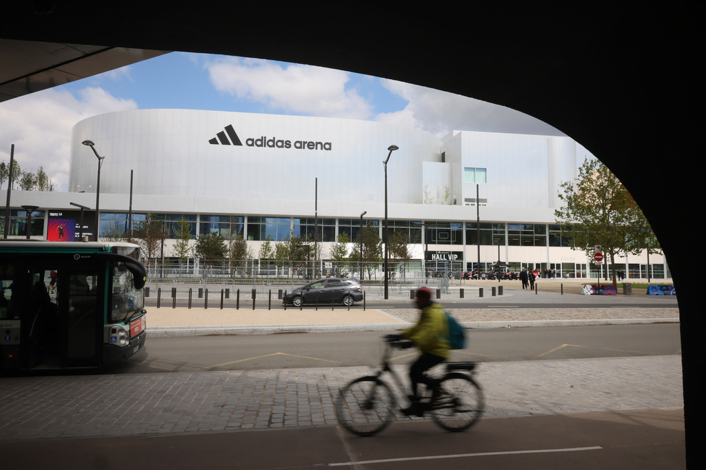 FILE - A cyclist rides past the Adidas Arena, April 18, 2024, in Paris, France. (AP Photo/Thomas Padilla, File)