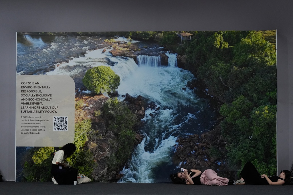 People rest as everyone waits for a deal at the COP30 U.N. Climate Summit, Saturday, Nov. 22, 2025, in Belem, Brazil. (AP Photo/Fernando Llano)