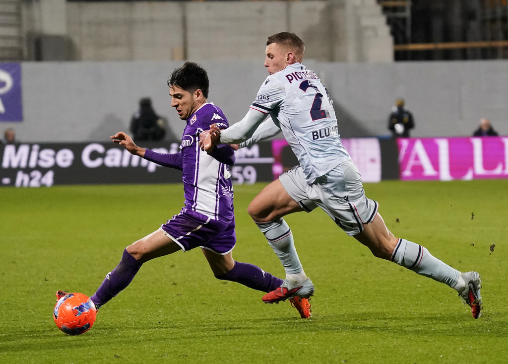Fiorentina's Fabiano Parisi, left, fight for the ball with Udinese's Jakub Piotrowski during the Serie A soccer match between Fiorentina and Udinese at the Artemio Franchi stadium, in Florence, Italy, Sunday, Dec. 21, 2025. (Marco Bucco/LaPresse via AP)