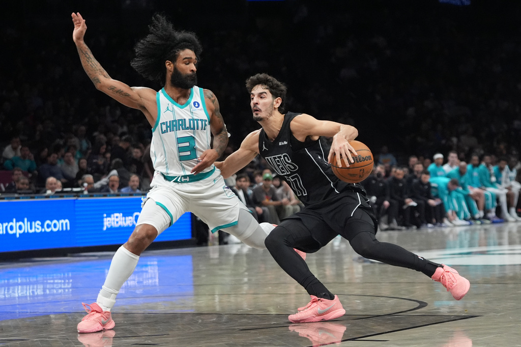 Charlotte Hornets' Coby White (3) defends Brooklyn Nets' Ben Saraf (77) during the second half of an NBA basketball game Tuesday, March 31, 2026, in New York. (AP Photo/Frank Franklin II)
