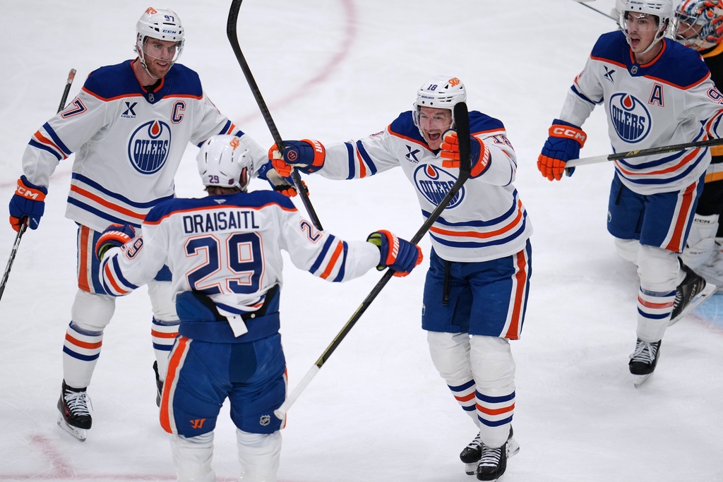 Edmonton Oilers' Leon Draisaitl (29) celebrates with Zach Hyman (18) and Connor McDavid (97) after scoring during the first period of an NHL hockey game against the Pittsburgh Penguins in Pittsburgh, Tuesday, Dec. 16, 2025. (AP Photo/Gene J. Puskar)