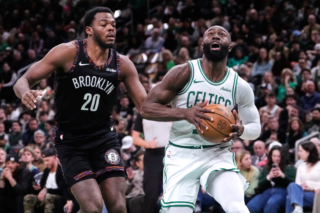 Boston Celtics guard Jaylen Brown, right, drives to the basket against Brooklyn Nets center Day'ron Sharpe during the first half of an NBA basketball game, Friday, Feb. 27, 2026, in Boston. (AP Photo/Charles Krupa)