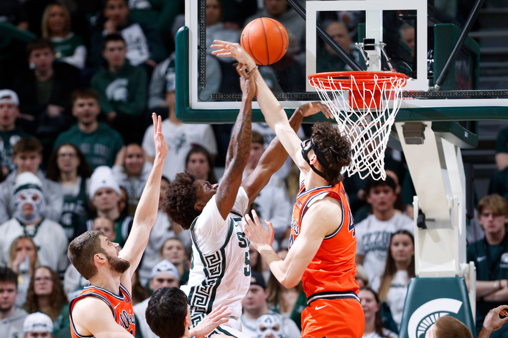 Illinois center Zvonimir Ivisic, center right, blocks a shot by Michigan State forward Coen Carr, center left, as Illinois center Tomislav Ivisic, left, defends during the first half of an NCAA college basketball game, Saturday, Feb. 7, 2026, in East Lansing, Mich. (AP Photo/Al Goldis)