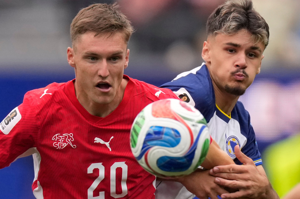 Switzerland's Michel Aebischer, left, and Bosnia's Kerim Alajbegovic eye the ball during the World Cup Group B soccer match between Switzerland and Bosnia in Inglewood, Calif., near Los Angeles, Thursday, June 18, 2026. (AP Photo/Mark J. Terrill)