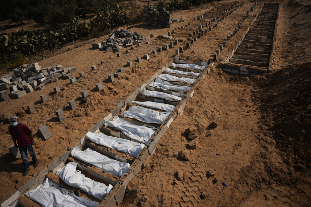 Bodies of unidentified Palestinians returned from Israel as part of the ceasefire deal are buried in a mass grave in Deir al-Balah, Gaza Strip, Wednesday, Nov. 5, 2025. (AP Photo/Abdel Kareem Hana)