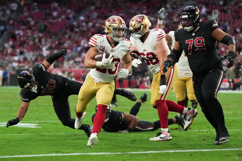 San Francisco 49ers running back Christian McCaffrey, middle, runs toward the end zone to score against the Arizona Cardinals during the second half of an NFL football game in Glendale, Ariz., Sunday, Nov. 16, 2025. (AP Photo/Rick Scuteri)