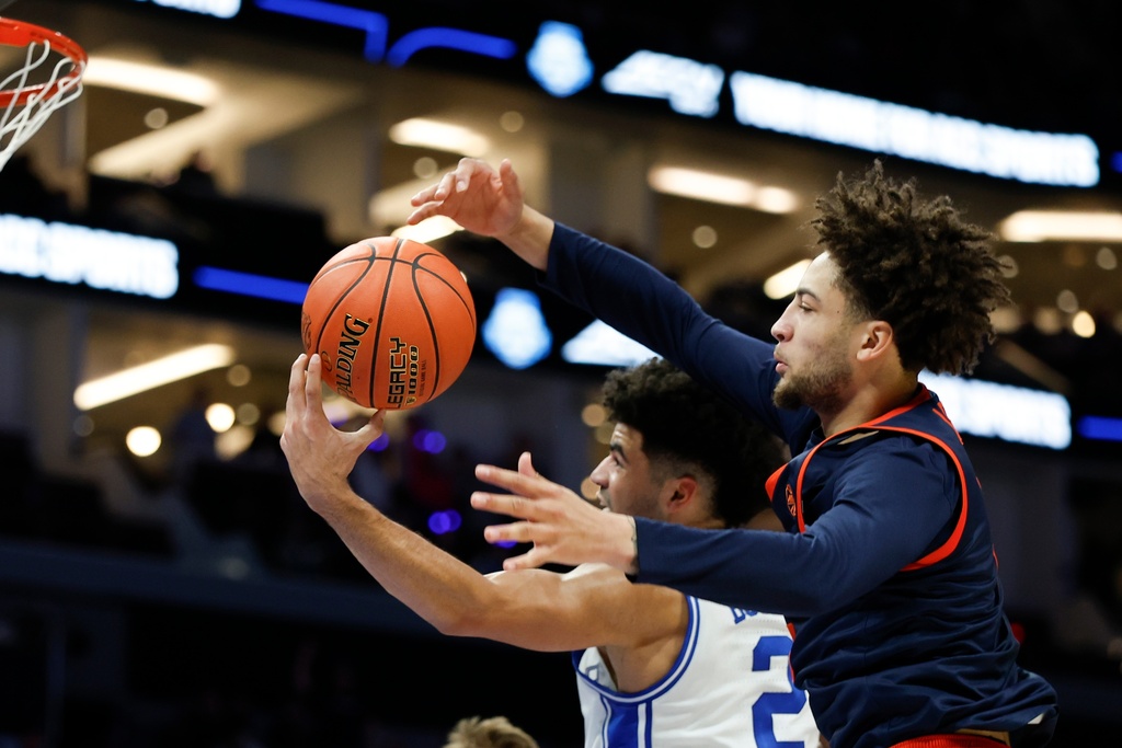 Virginia guard Sam Lewis, right, battles Duke guard Cayden Boozer for a rebound during the first half of an NCAA college basketball game in the championship of the Atlantic Coast Conference tournament in Charlotte, N.C., Saturday, March 14, 2026. (AP Photo/Nell Redmond)