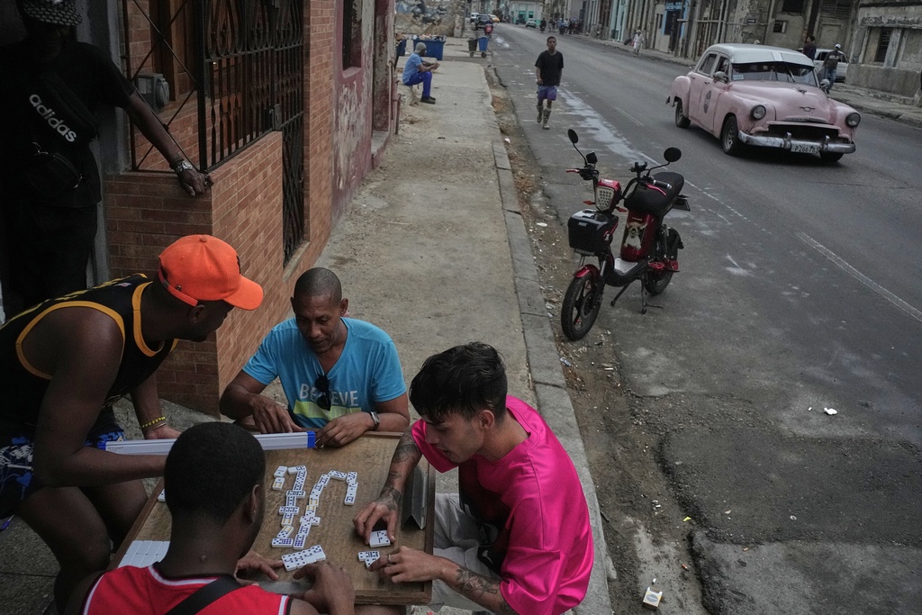 People play dominoes outdoors during a power outage in Havana, Cuba, Wednesday, Dec. 3, 2025. (AP Photo/Ramon Espinosa)