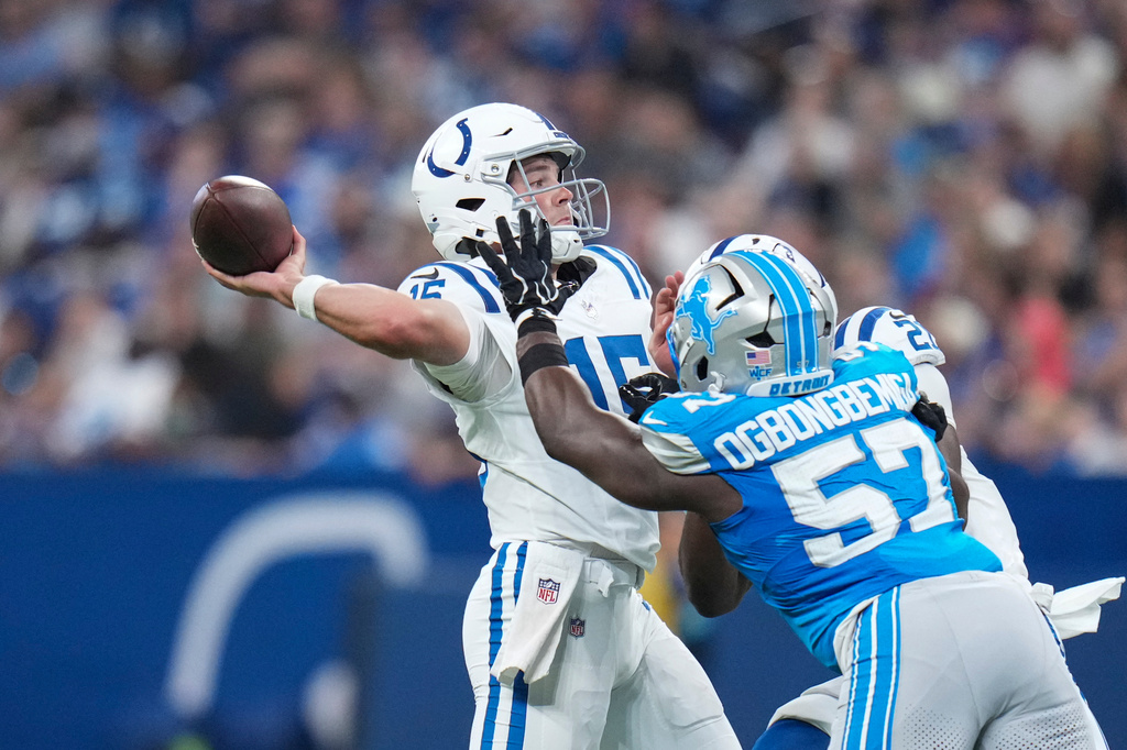 Indianapolis Colts quarterback Riley Leonard (15) throws over Detroit Lions linebacker Amen Ogbongbemiga (57) during the first half of a preseason NFL football game in Indianapolis, Saturday, Aug. 29, 2026. (AP Photo/Jeff Roberson)