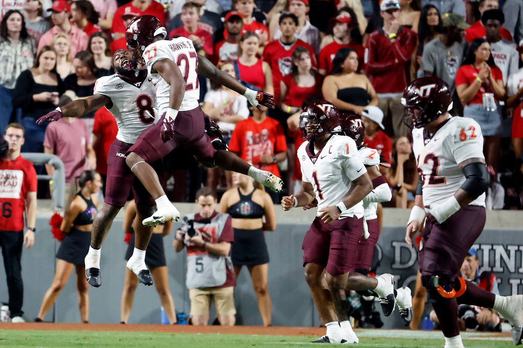 Virginia Tech running back Marcellous Hawkins (27) celebrates his touchdown with Virginia Tech's Christian Ellis (8) as other players head to the sideline during the first half of an NCAA college football game against North Carolina State in Raleigh, N.C., Saturday, Sept. 27, 2025. (AP Photo/Karl DeBlaker)