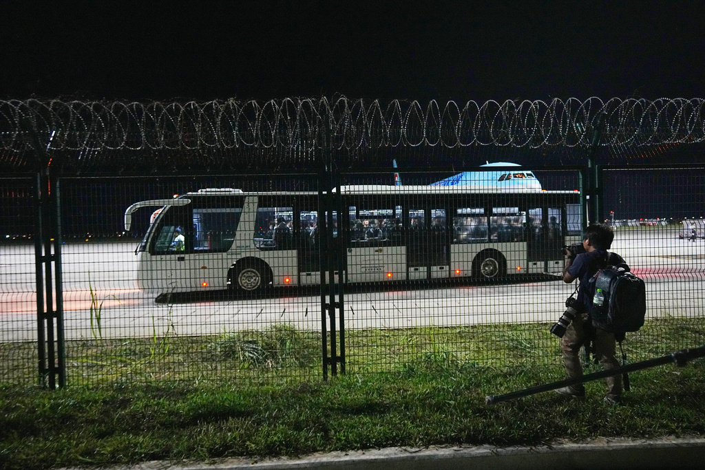 Korean Air staff and police officers ride a bus at Techo International Airport in Kandal province, Cambodia, Friday, Oct. 17, 2025. (AP Photo/Heng Sinith)