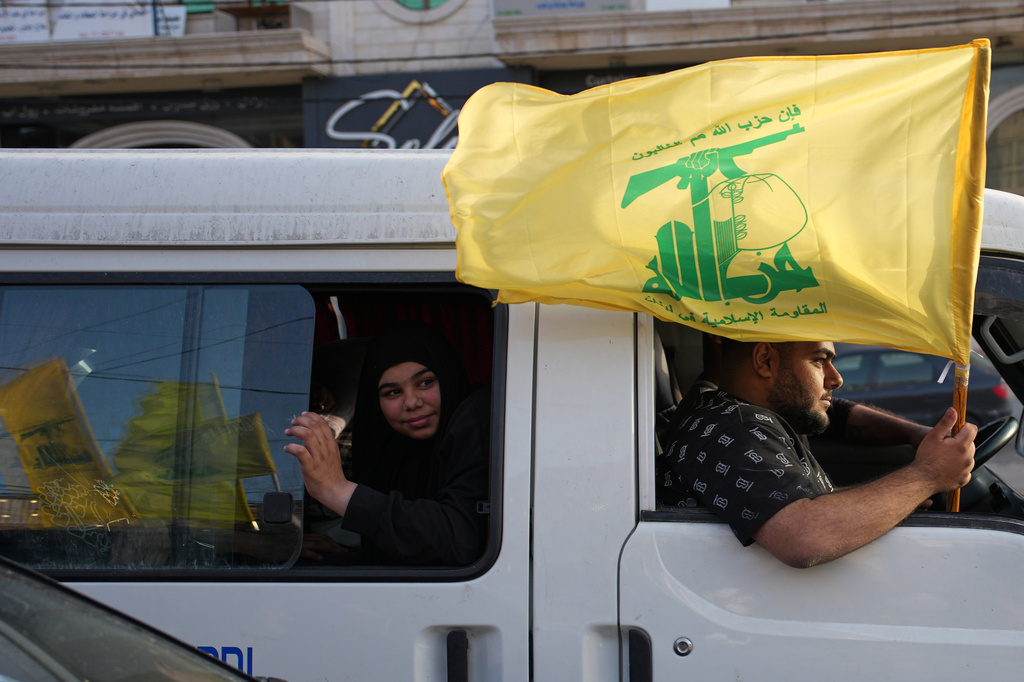Displaced residents hold a Hezbollah flag as they celebrate while returning to their villages following a ceasefire between Israel and Hezbollah, in Zefta, southern Lebanon, Friday, April 17, 2026. (AP Photo/Hassan Ammar)