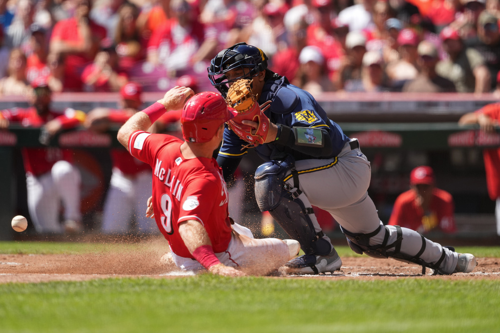 Cincinnati Reds' Matt McLain, left, scores as Milwaukee Brewers catcher Bo Naylor bobbles the throw to home plate in the second inning of a baseball game, Sunday, Sept. 6, 2026, in Cincinnati. (AP Photo/Kareem Elgazzar)