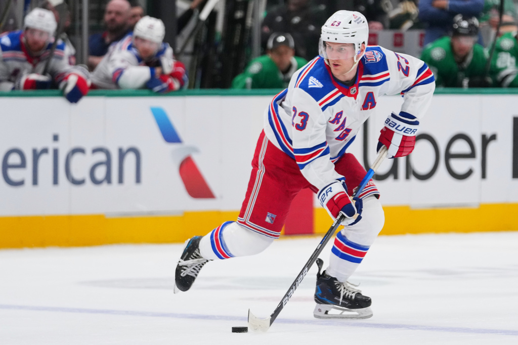 FILE - New York Rangers defenseman Adam Fox skates with the puck during the second period of an NHL hockey game between the Dallas Stars and the New York Rangers, April 11, 2026, in Dallas. (AP Photo/Julio Cortez, File)