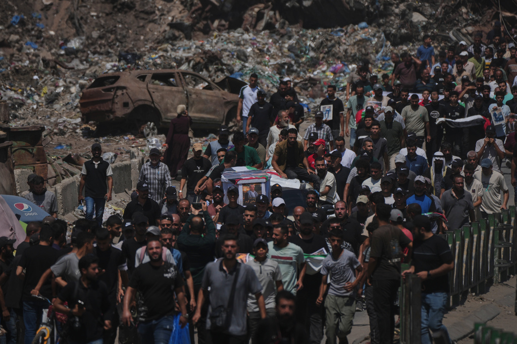 Mourners carry the flag-draped bodies of Palestinians killed in Israeli strikes during the war with Hamas, whose remains were recently recovered from the rubble, in Gaza City, Thursday, Aug. 20, 2026. (AP Photo/Jehad Alshrafi)